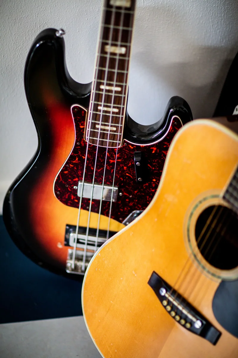 corpo sunburst de um baixo elétrico ao lado do corpo de um violão acústico