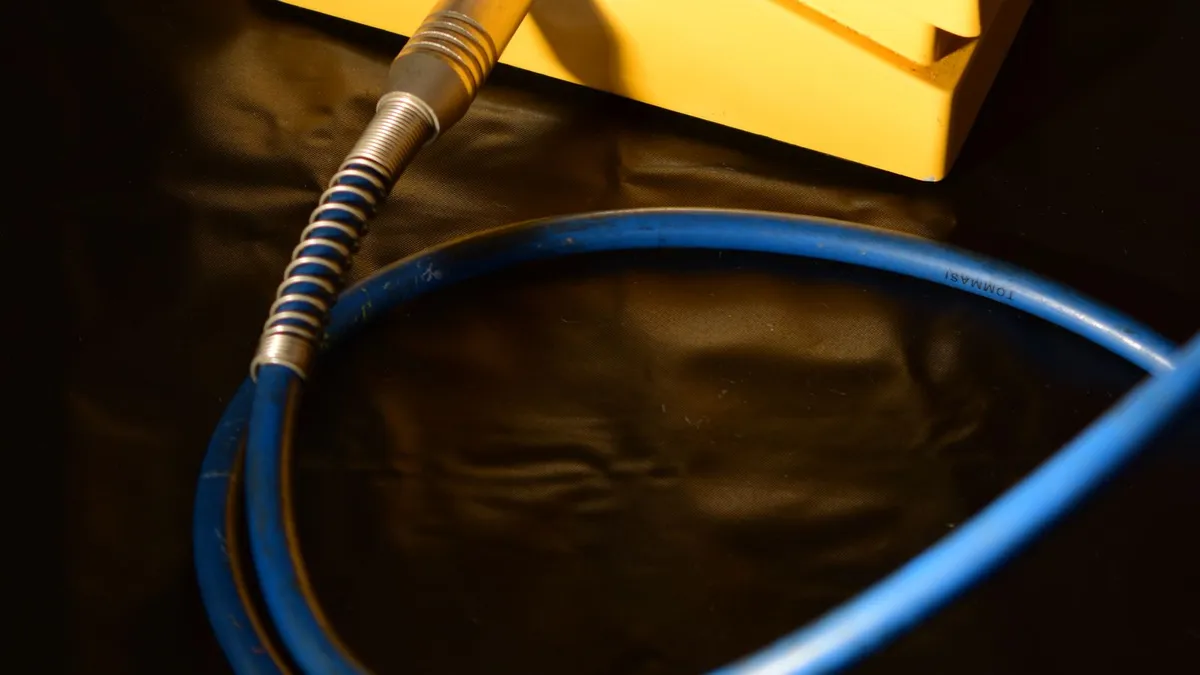cabo azul com malha dourada ligado em um pedal amarelo de efeito