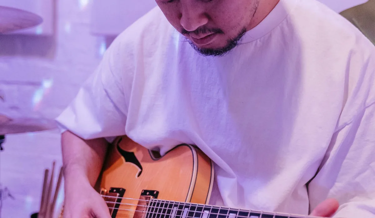 pessoa tocando violão sozinha em casa, clima de estudo autodidata
