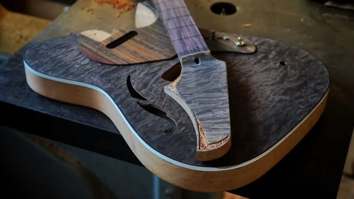corpo de guitarra ainda sem acabamento sobre a bancada, com o veio da madeira à mostra