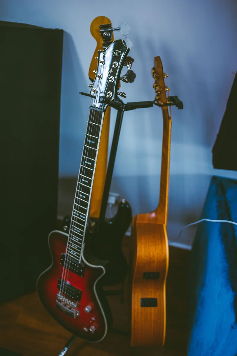 três guitarras elétricas nacionais lado a lado em estúdio, cores diferentes