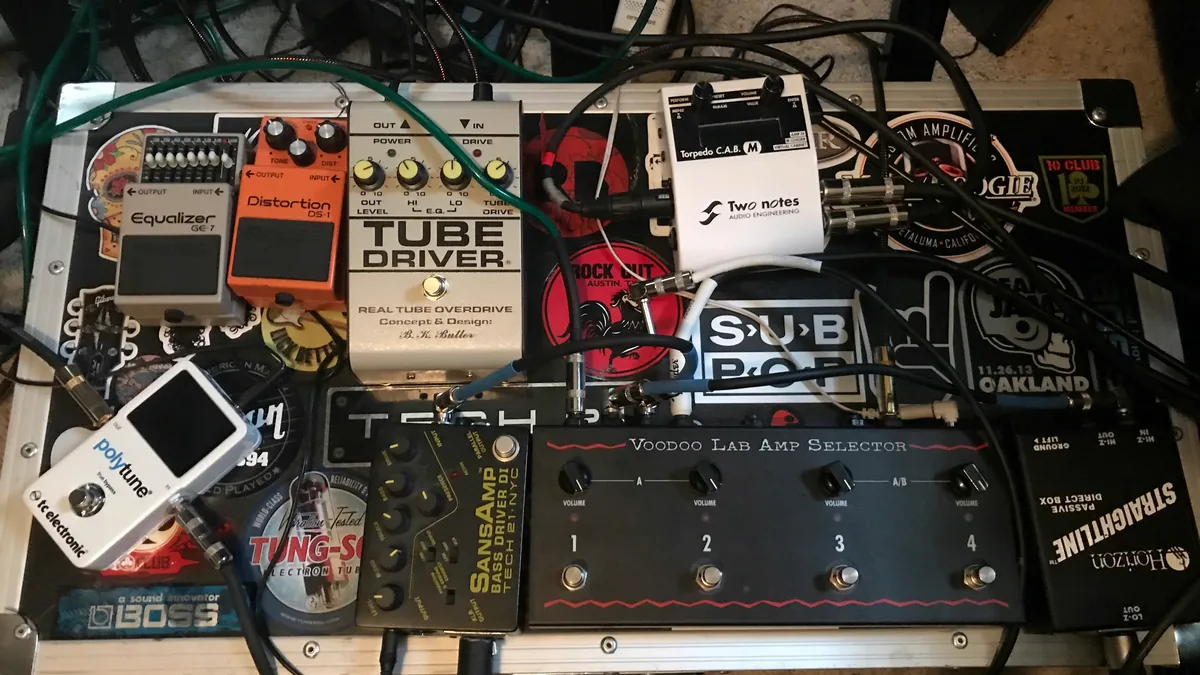 pedalboard montado em um estúdio, com vários pedais de efeito e cabos de alimentação ligados