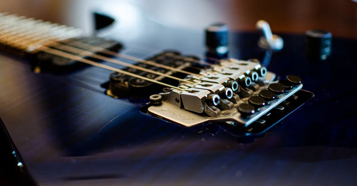 ponte de trava dupla de uma guitarra azul escura, vista de perto