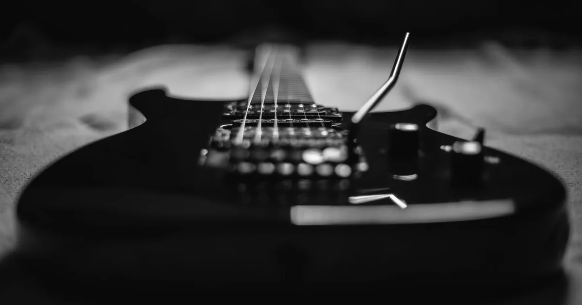 guitarra preta com humbuckers e alavanca em preto e branco
