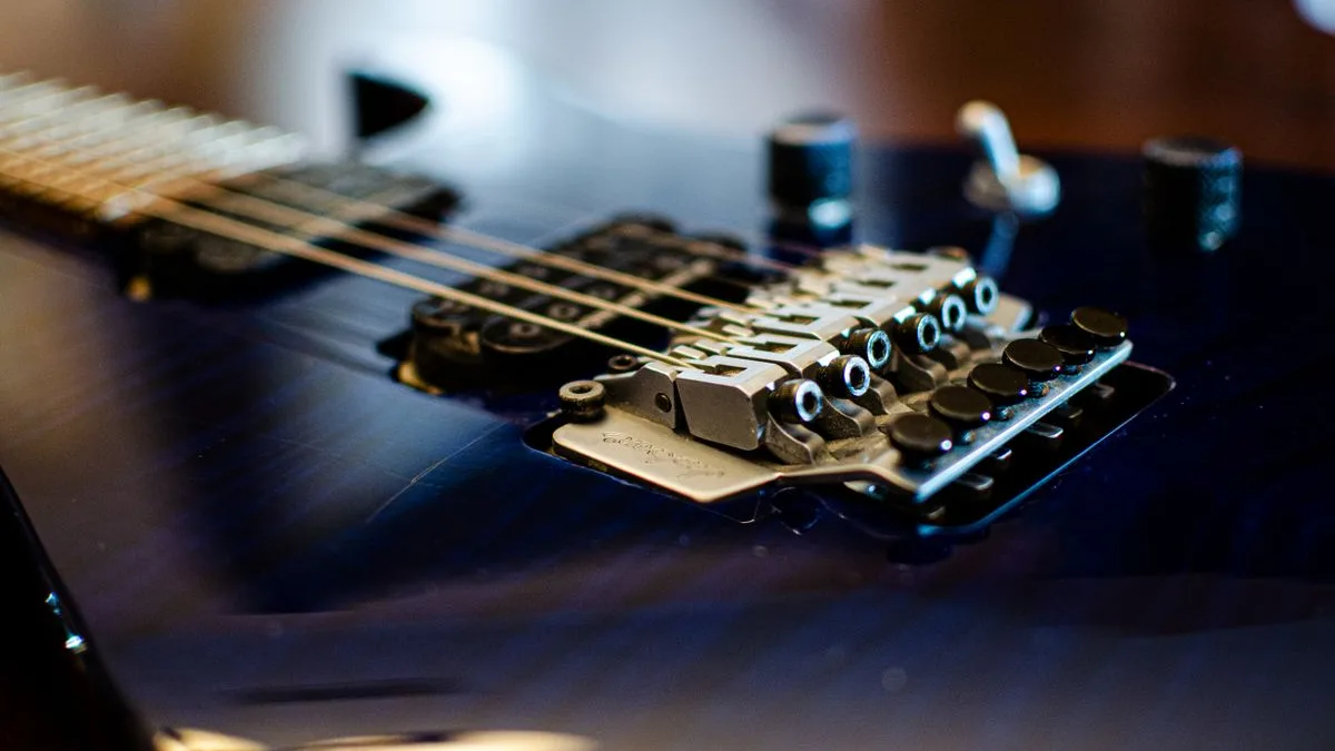 ponte de guitarra com trêmolo travado e parafusos de ajuste sobre corpo azul brilhante