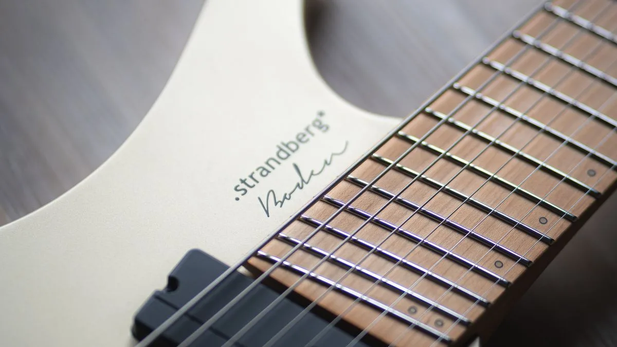 detalhe de uma guitarra Strandberg branca com braço de trastes multiescala e sem headstock
