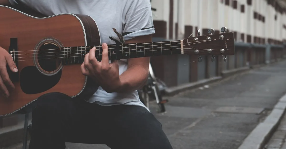 Guitarra elétrica e violão folk lado a lado em uma bancada de madeira