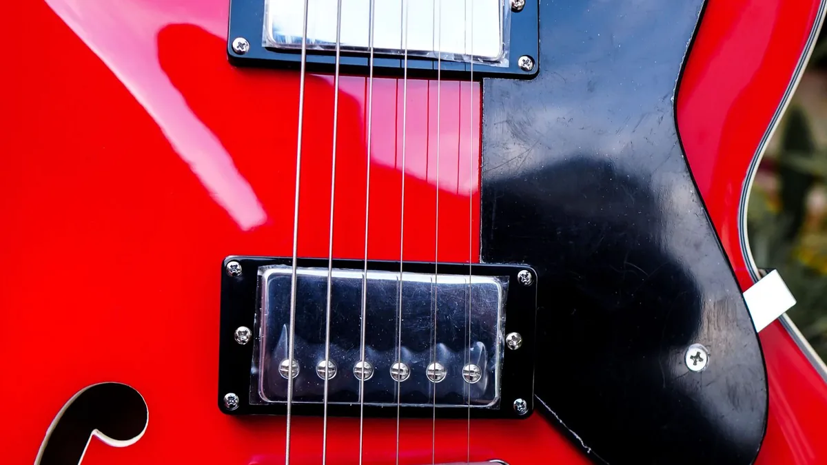 detalhe de um humbucker e do furo em F em uma guitarra semi-acústica vermelha