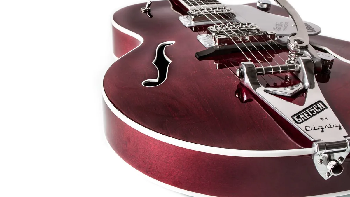 detalhe de uma guitarra semi-acústica Gretsch vinho com ponte Bigsby e furo em F