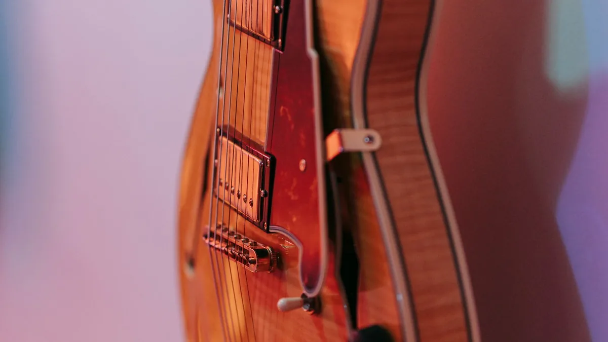 guitarra semi-acústica de corpo laranja vista de lado, mostrando a espessura do corpo semi-oco