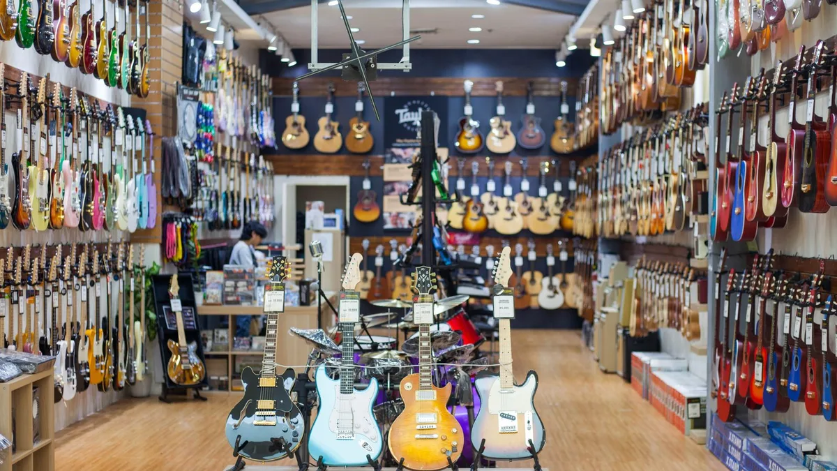 loja de instrumentos com paredes cheias de guitarras elétricas e várias guitarras em pé no centro