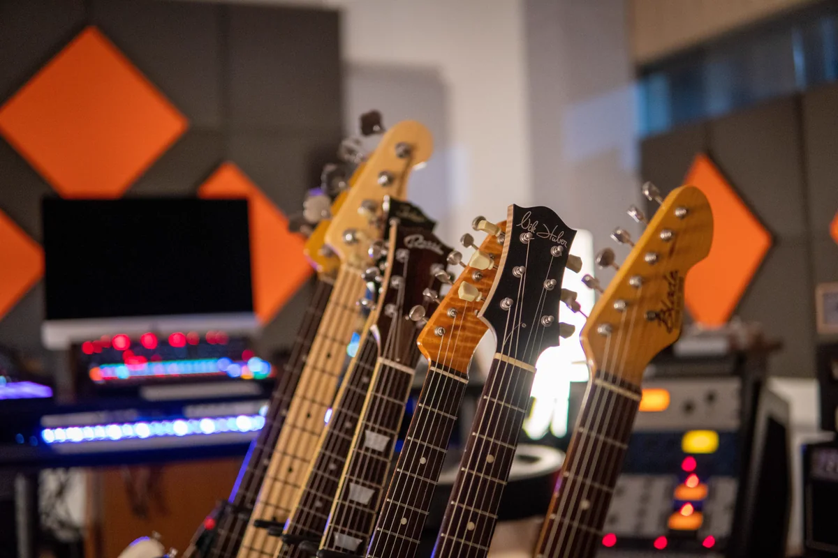 Headstocks de guitarras de diferentes marcas alinhadas em estúdio