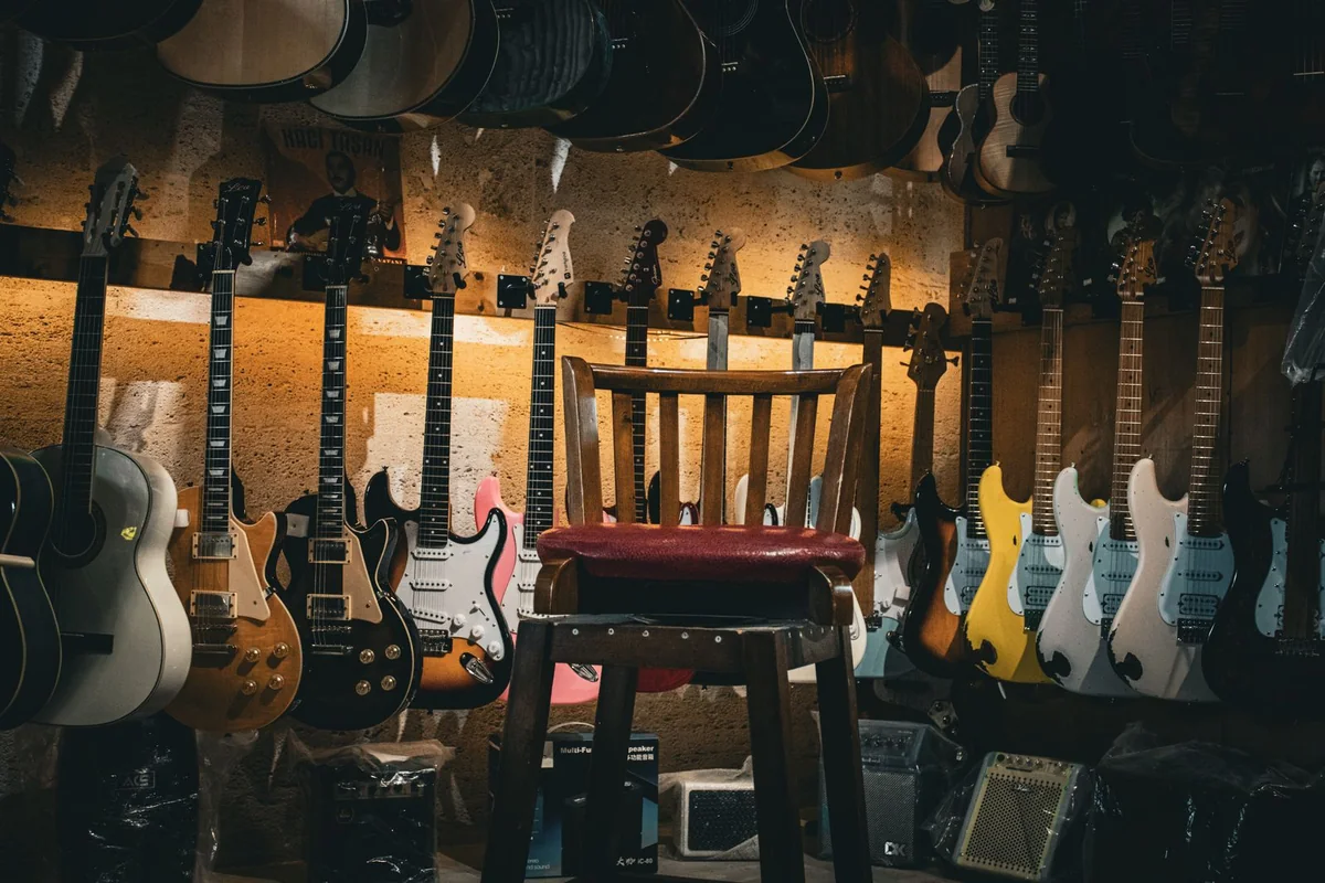loja com guitarras penduradas na parede e uma fileira de cubos pequenos de prática no chão