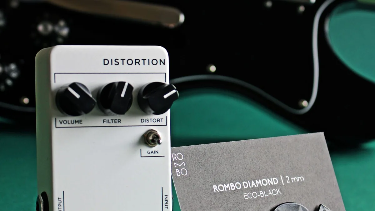 pedal de distorção branco com os controles de volume, filtro e distorção