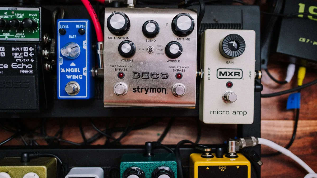 pedalboard montado com vários pedais ligados por cabos patch e fonte