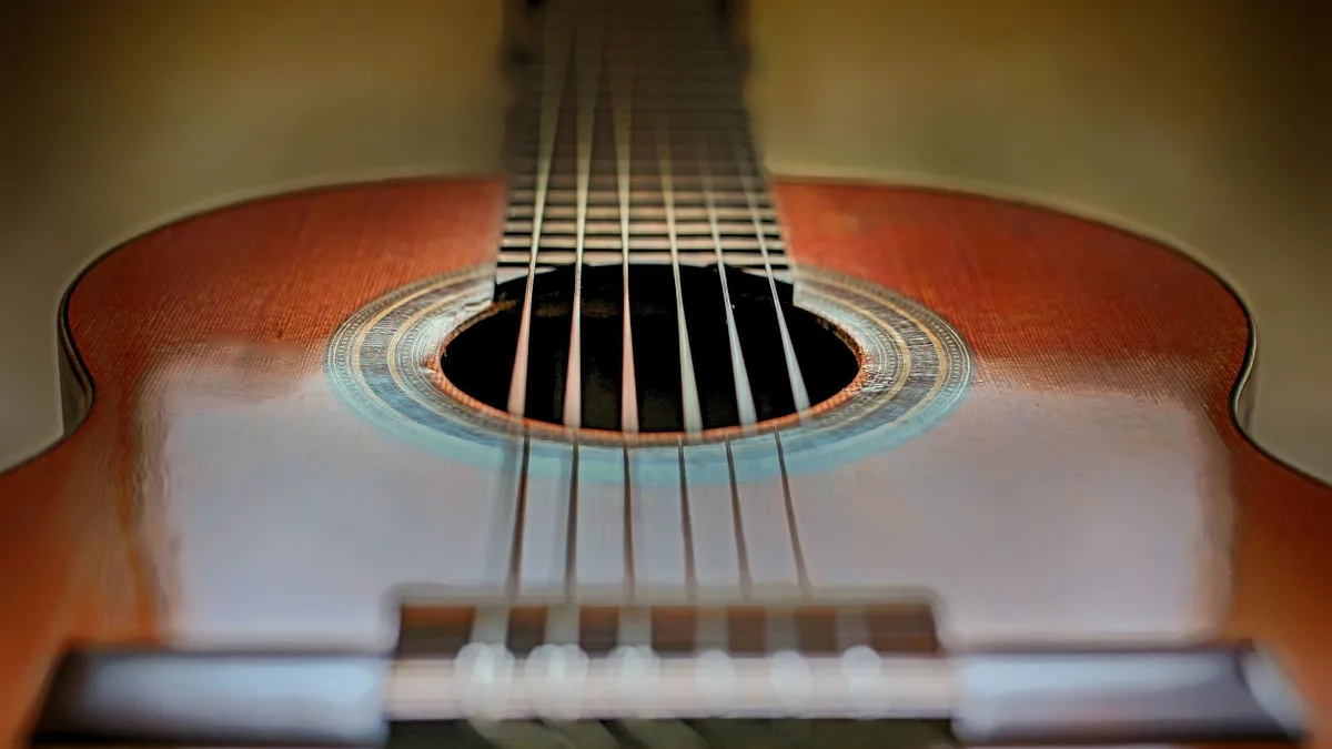 tampo e roseta de um violão de nylon visto de cima, com as cordas em perspectiva