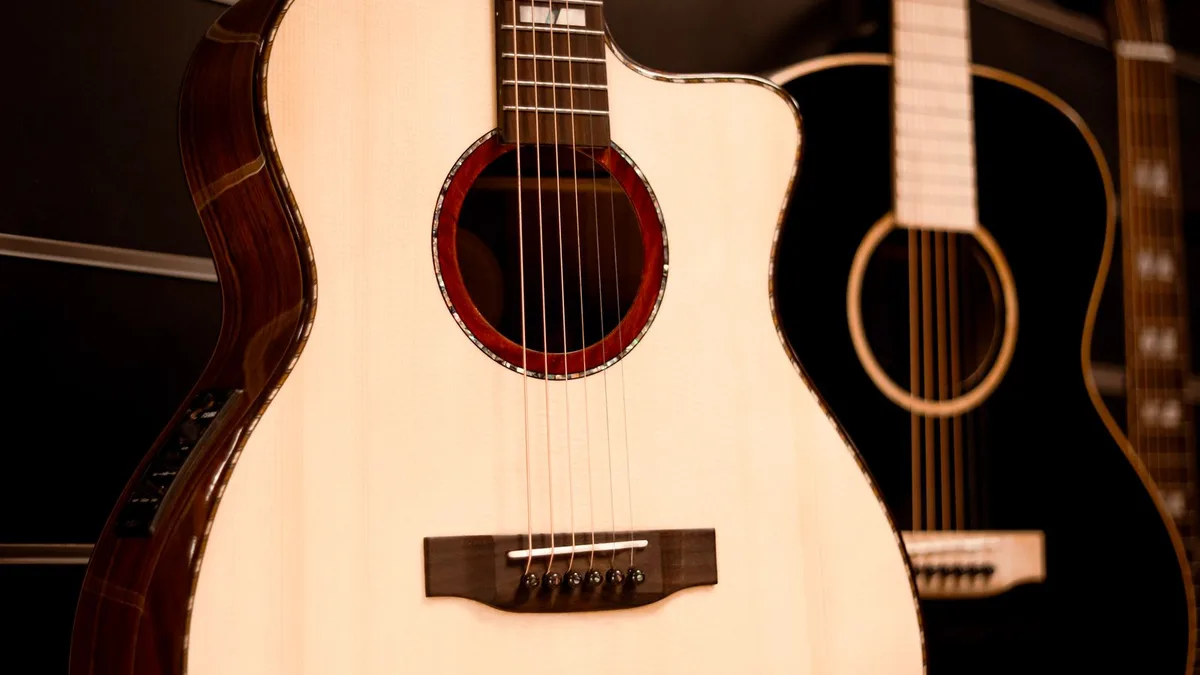 violão eletroacústico de cutaway com tampo claro exposto em uma loja de instrumentos