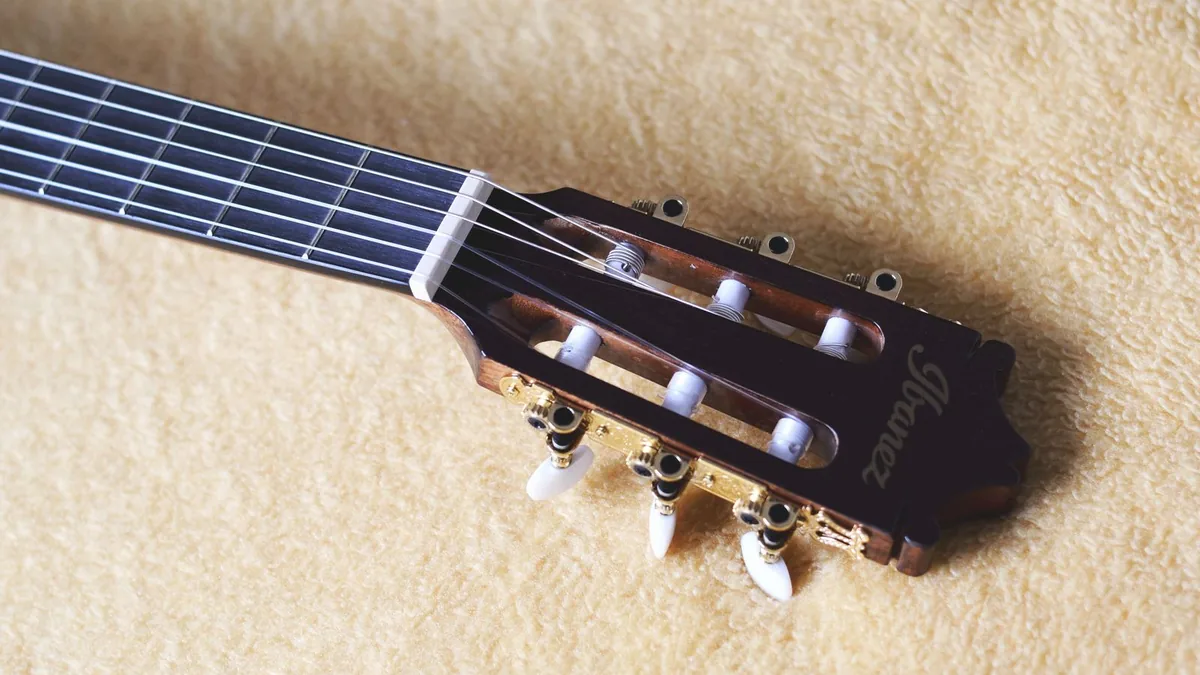 headstock vazado de violão clássico com as cordas de nylon amarradas nos roletes